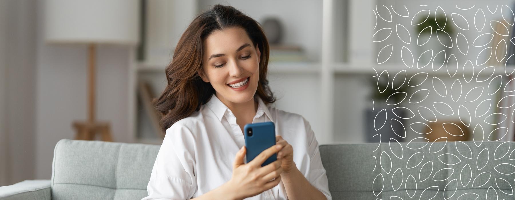 a woman sitting on a couch, looking at her phone