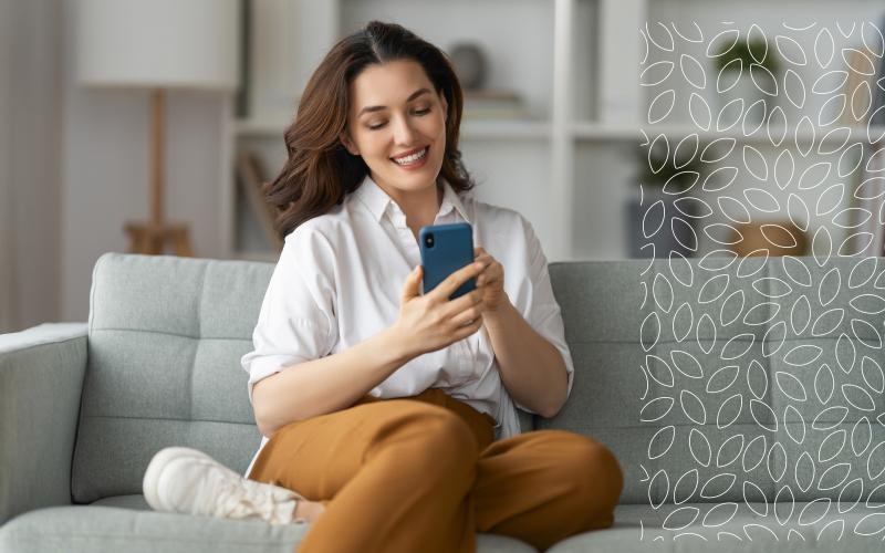 a woman sitting on a couch, looking at her phone